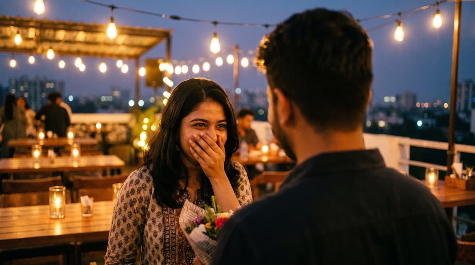 A surprised, happy woman on a rooftop decorated with string lights