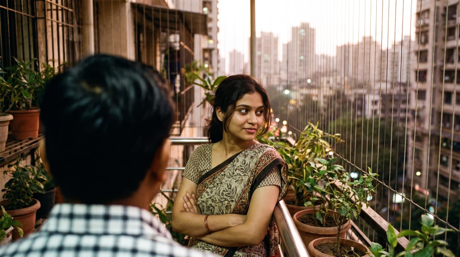 A woman with arms crossed on a balcony, a small smile starting