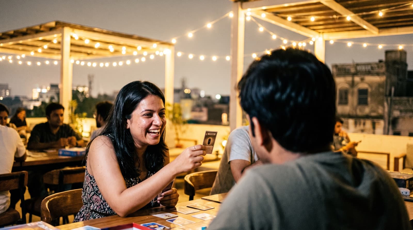 A woman laughing during a rooftop board-game night