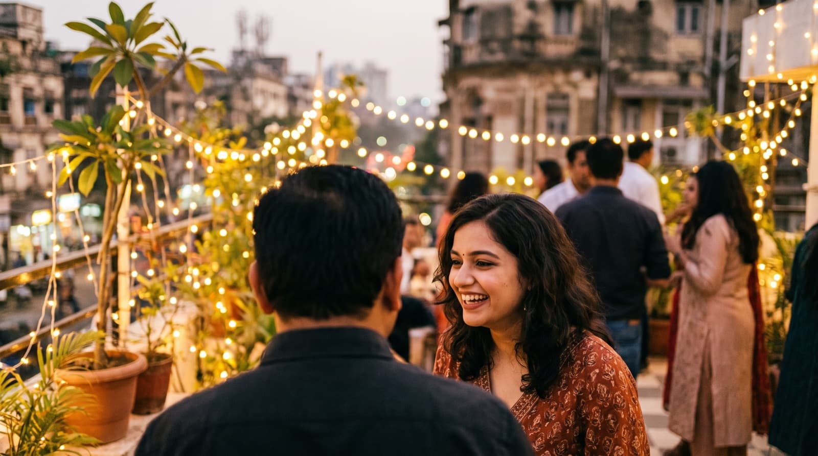 A woman laughing, charmed, at a rooftop party